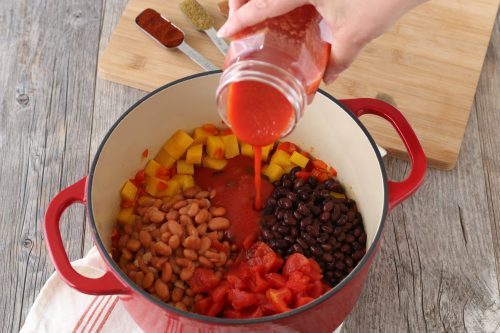 Now we are adding liquid to our vegetarian chili recipe before we allow this tasty butternut squash chili to simmer.