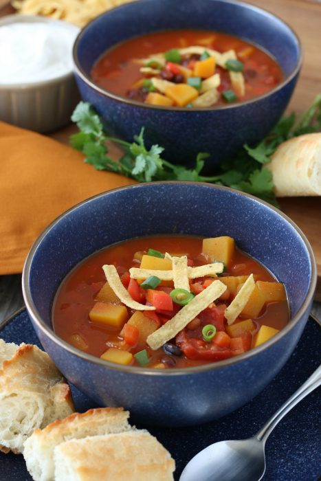 Another view of the finished vegetarian chili recipe in a bowl with a spoon, the crunchy tortilla strip topping adds a nice crunch! 